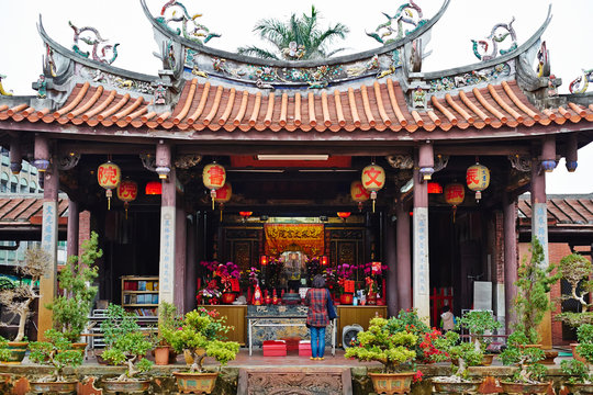 People pray for god in traditional oriental heritage temple in Taiwan (Chinese Translation on lantern : Jen-wen Academy, on board : improve the society by education).