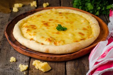 Homemade cheese pizza, Heorgian food - Hachapuri on wooden background. Selective focus