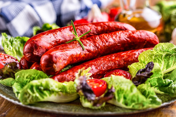 Sausage. Chorizo sausage. Raw smoked sausage with vegetable decoration.Lettuce salad herb rosemary tomato garlic olive oil.