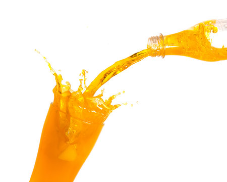 Pouring orange juice from bottle into glass with splashing., Isolated white background.
