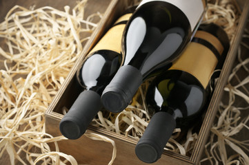 Wine bottles in wooden box and straw