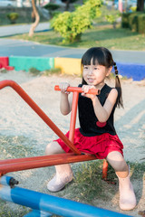 Happy kid, asian baby child playing on a seesaw