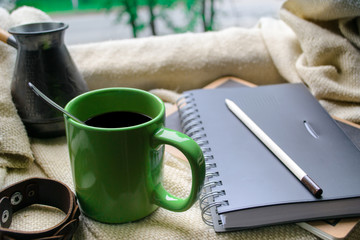 cup of coffee and a book on a window
