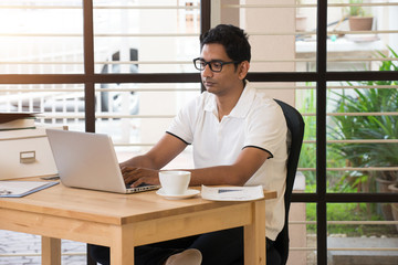 young indian man working from home office