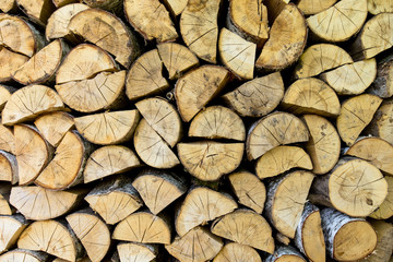 Firewood texture background. Chopped birch firewood, stacked in woodshed and snowbound
