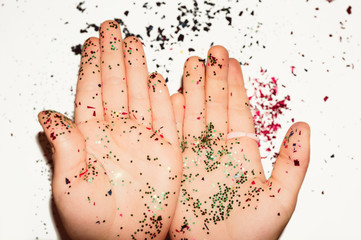 Closeup of two children's palm with colorful glitter.  The concept of children's creativity