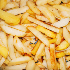 French fries closeup background.  Texture of fast food meal, top view on french fries in the pan.