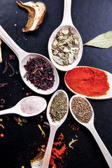 spice in wood spoon on a black background. food