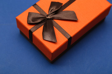 orange gift box with brown bow on a blue background