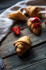A delicious breakfast of strawberries and bread on wooden background. Fruit, food, sandwiches, cheese. Vintage style.