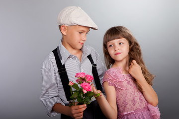 The boy gives a flower to the girl