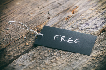 Closeup of pricing tag with twine and "Free" text on wooden background