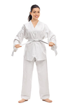 Woman in a white kimono tying her belt