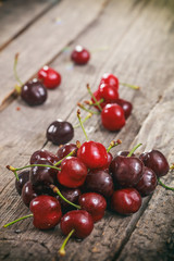 Fototapeta na wymiar A heap of red cherries, on wooden surface.
