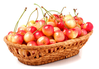 yellow cherries in a wicker basket isolated on white background