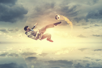 Obraz na płótnie Canvas Businessman kicking ball