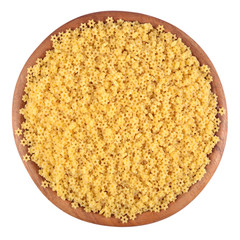 Uncooked italian pasta stars in a wooden bowl on a white