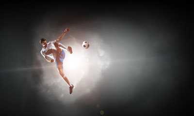 Obraz na płótnie Canvas Soccer player hitting ball