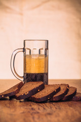 Russian brew in mug  and loaf of rye flour on wooden background