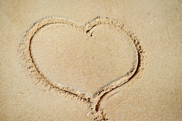 Love heart drawn on sand background