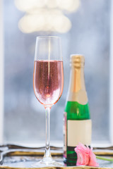 a nice glass of pink champagne and a bottle on the back