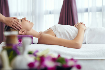 Obraz na płótnie Canvas Woman receiving relaxing head massage in spa salon