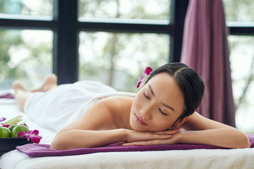 Obraz premium Beautiful Asian woman sleeping after relaxing spa procedure