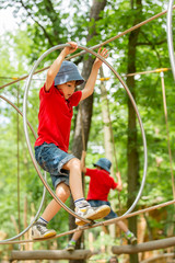 Cute child, boy, climbing in a rope playground structure