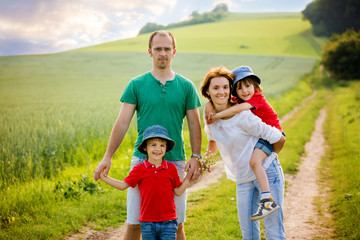 Family of four in field on a rural path, springtime, having fun