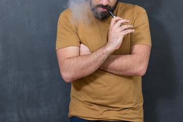 Black haired handsome man vaping e-cirarette mod - blowing cloud