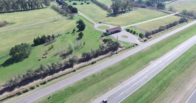 Aerial drone scene of highway in the countryside. Camera moves along the road. Cars and trucks circulation is registered. Traffic movement in rural areas.
