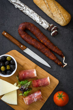 Spanish serrano ham, cheese and sausage on slate background
