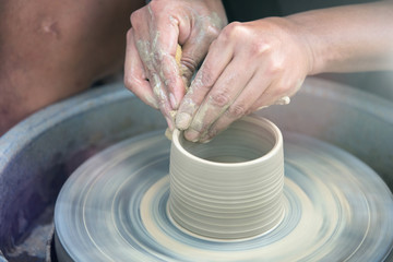 Hands working on pottery wheel