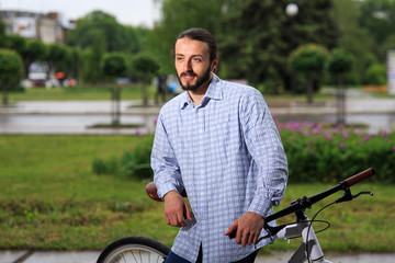 young hipster man with fixed gear bike on city street