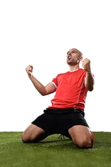 Foto auf Acrylglas happy and excited football player in red jersey celebrating scoring goal kneeling on grass pitch © Wordley Calvo Stock