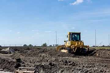 Obraz premium Bulldozer machine is leveling construction site
