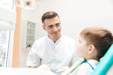 Dentist examining teeth of little boy