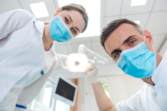 Two dentists making dental treatment to a patient