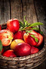 Fresh organic peaches in wooden basket with copy space 