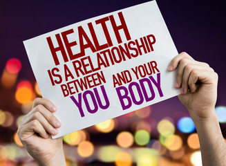 Health is a Relationship Between You and Your Body placard with night lights on background
