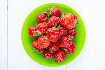 Top view of green plate with strawberries