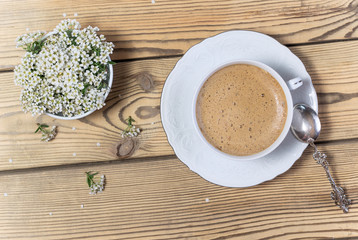 Vintage cup of coffee and flowers on wooden table
