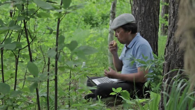 Man communicates via Skype in the forest, using the mobile Internet