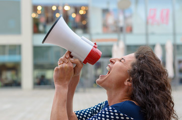 Young woman protester shouting into a megaphone