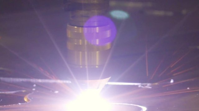 Sparks of light coming from the plasma cutter while cutting a big metal sheet