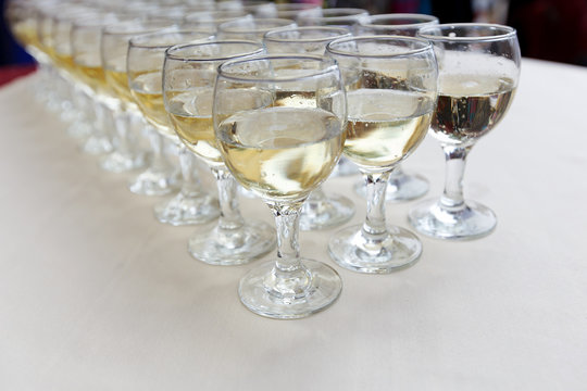 Rows of champagne glasses on table on colorful tablecloth. Wedding ceremony