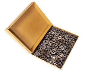 Old cardboard box with many small ball bearings isolated on white