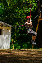 Young woman climbing in adventure climbing high wire park