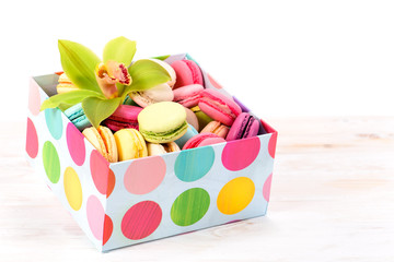 box with a fresh flower orchid cymbidium and delicious macaroon