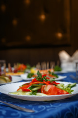 Variety of delicious dishes on plates on blue tablecloth at restaurant